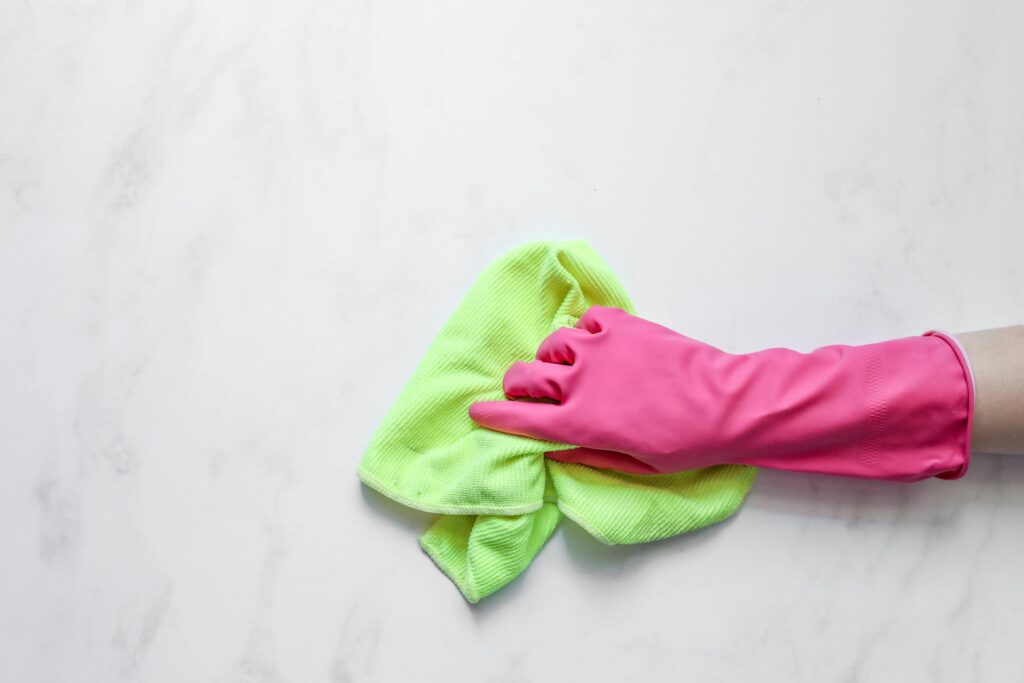 a pink glove on the housecleaners hand who is scrubbing a countertop at cerdehouseclening in asheville nc